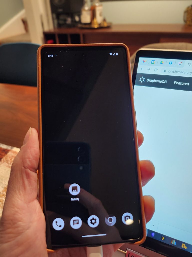 A smart phone with a plain black background and only 6 installed applications. Graphene OS, a privacy focused fork of Android, was just freshly installed.